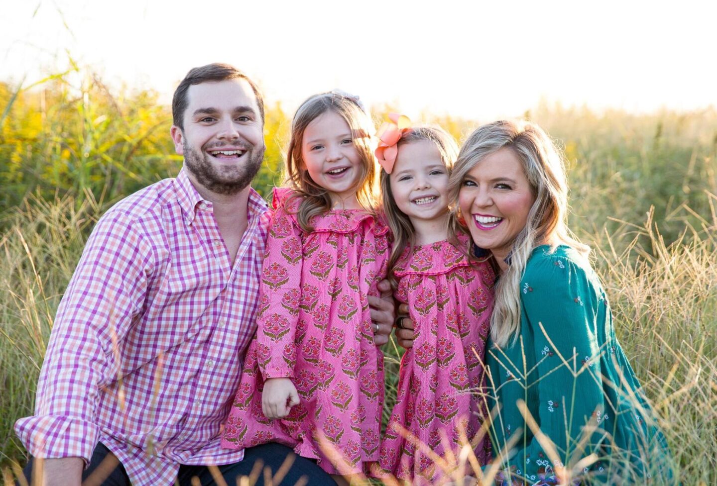 10 Year Wedding Anniversary by popular Nashville lifestyle blog, Hello Happiness: image of a mom and dad and their two young daughters standing together in a field. 
