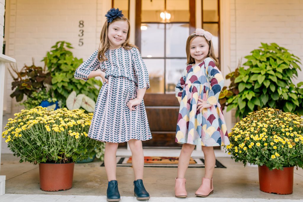 The Friday Five...by popular Nashville life and style blog, Hello Happiness: image of a two little girls standing together outside and wearing The Frilly Frog CAROLINE DRESS - CRYSTAL ROSE LEAVES, Boden navy Leather Chelsea Boots, The Frilly Frog AMMA DRESS - MULTI MERMAID, and Target Cat and Jack Toddler Girls' Ashley Fashion Boots.