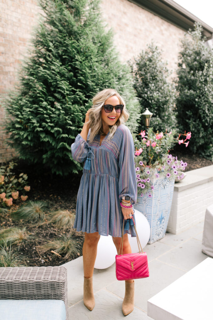 Under $100 by popular Nashville fashion blog, Hello Happiness: image of Natasha Stoneking wearing a Asos Metallic tiered smock dress, tan ankle boots, and holding a pink YSL purse. 