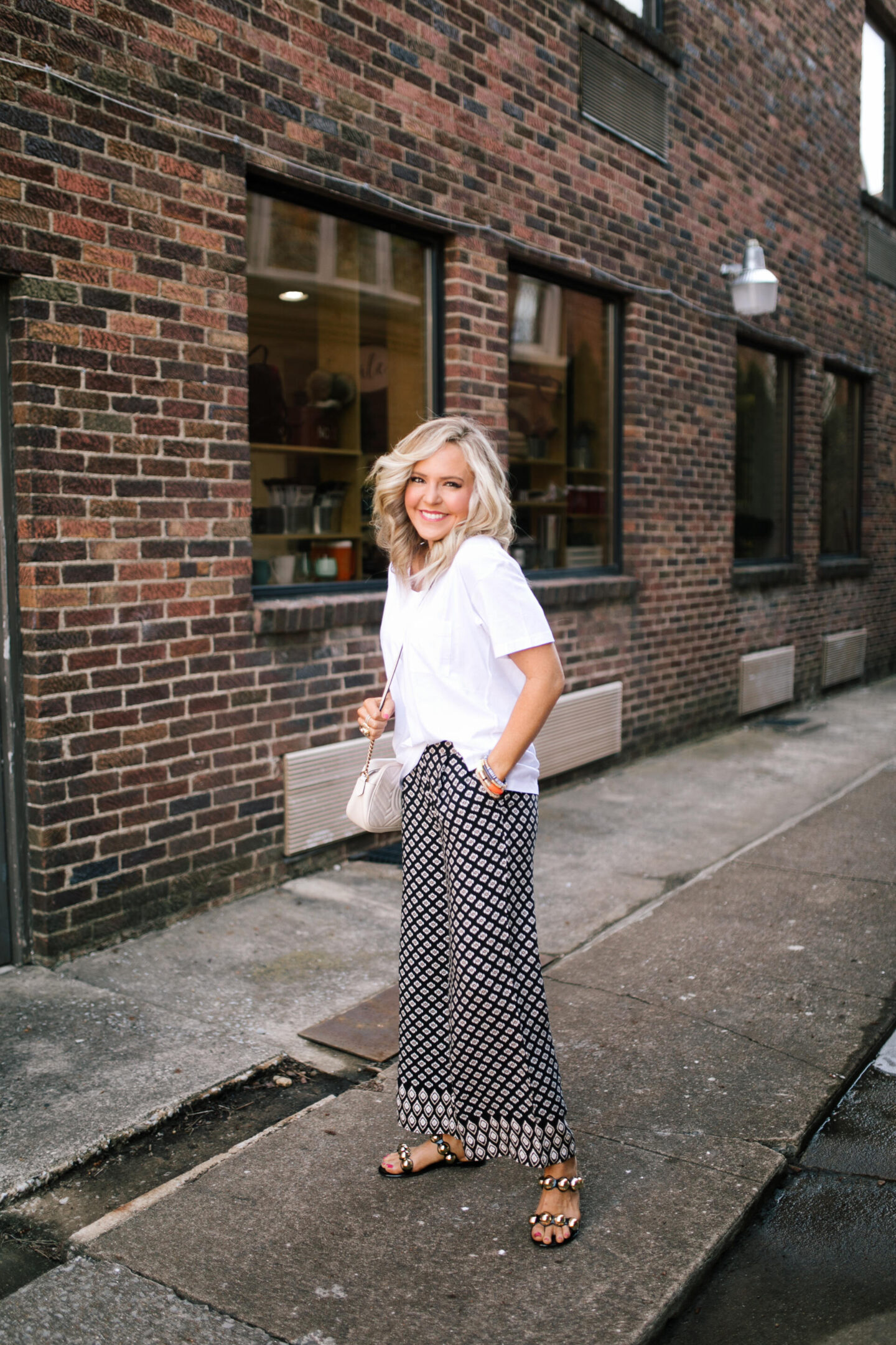 Spring Break Outfits by popular Nashville fashion blog, Hello Happiness: image of Natasha Stoneking wearing a pair of wide leg crop pants, v-neck shirt and jelly sandals. 