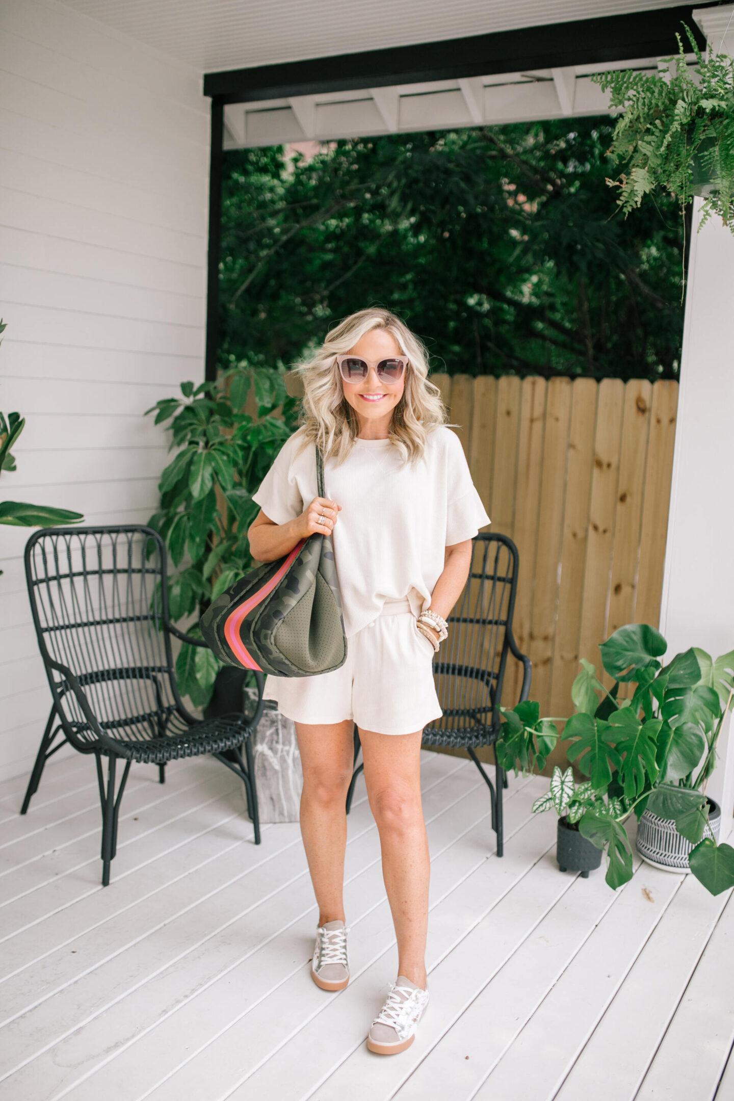 Labor Day Deals by popular Nashville life and style blog, Hello Happiness: image of Natasha Stoneking wearing a waffle stitch top, waffle stitch shorts, Zina sneakers, and holding a Neoprene tote.
