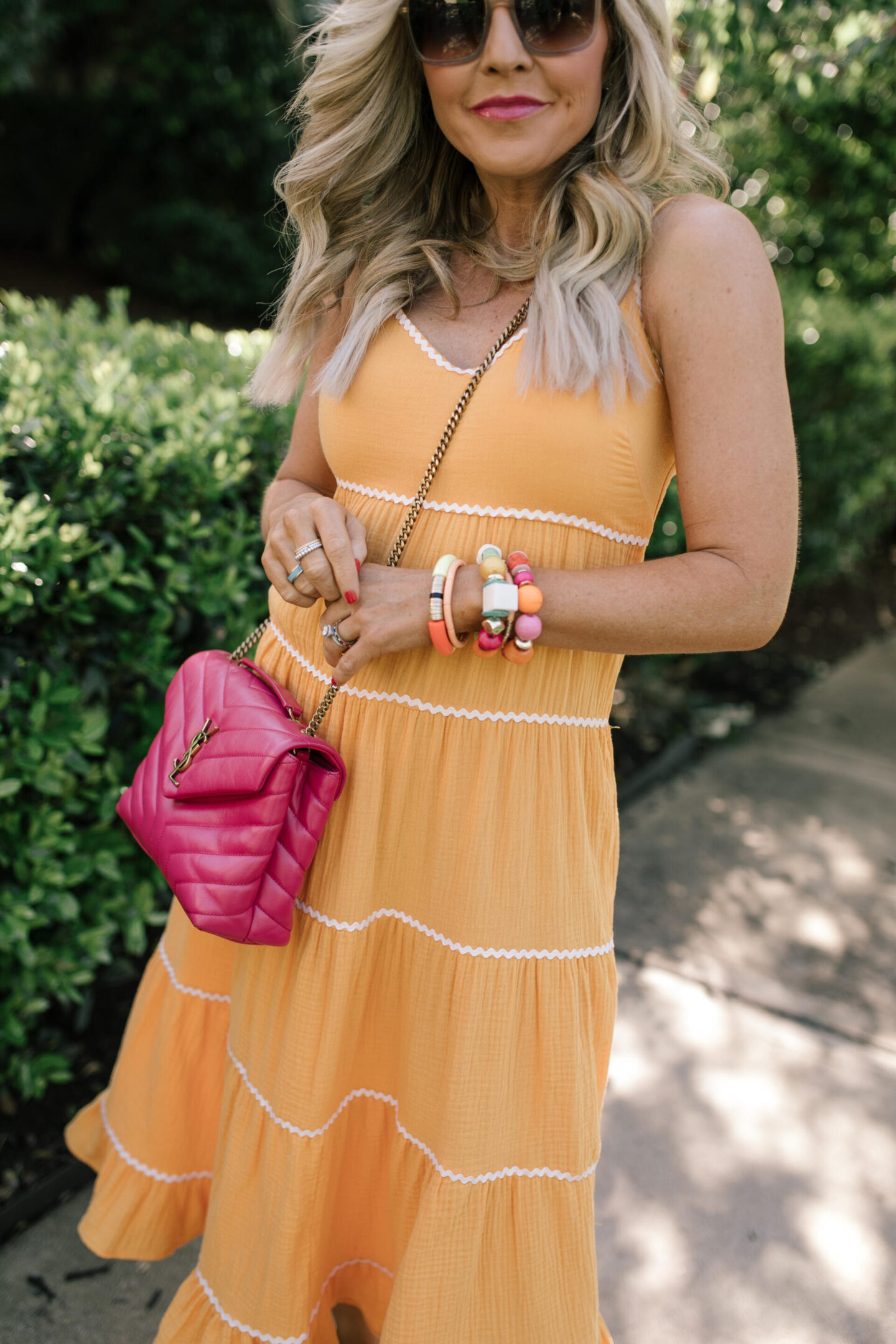 Scoop Dress by popular Nashville fashion blog, Hello Happiness: image of a woman wearing Scoop orange ric rac dress, multi color stretch bracelets, and a pink YSL bag. 
