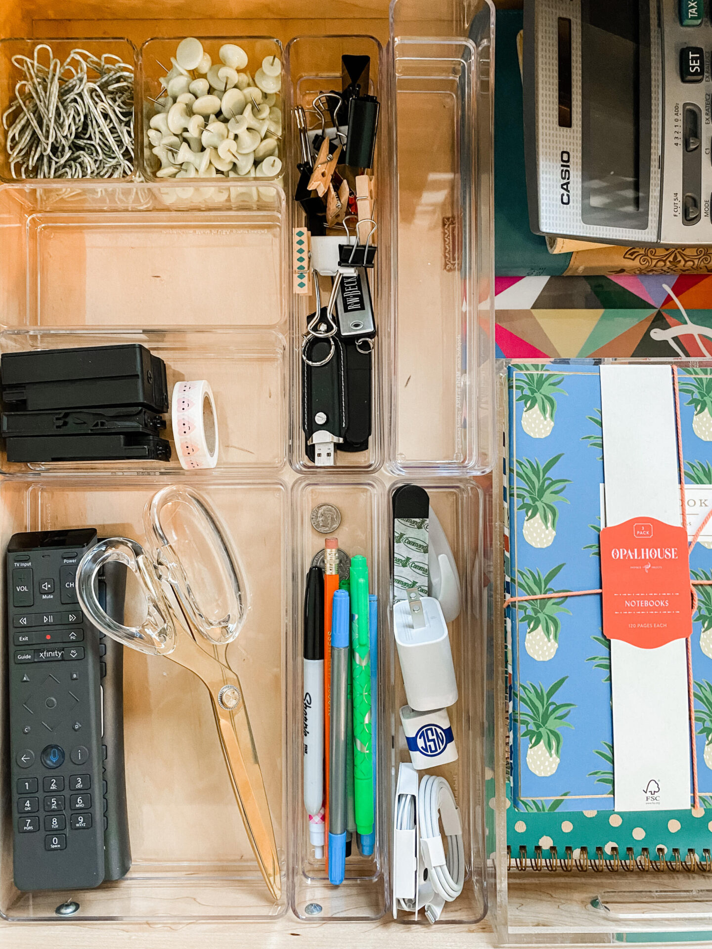 Acrylic Office Supplies by popular Nashville life and style blog, Hello Happiness: image of acrylic drawer organizers filled with paper clips, push pins, acrylic handle scissors, markers, notebooks, washi tape, and remote controls. 