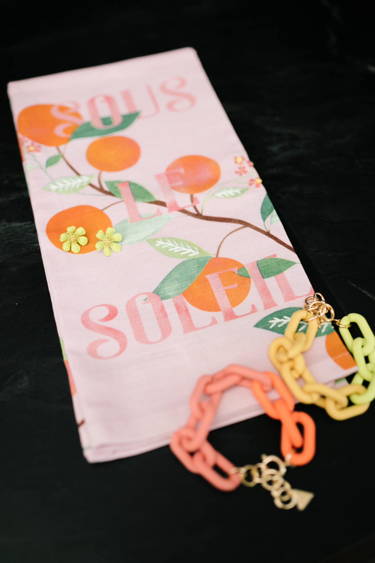 Anthropologie Sale by popular Nashville life and style blog, Hello Happiness: image of resin chain link bracelets, yellow flower stud earrings, and a Sous Le Soleil hand towel.