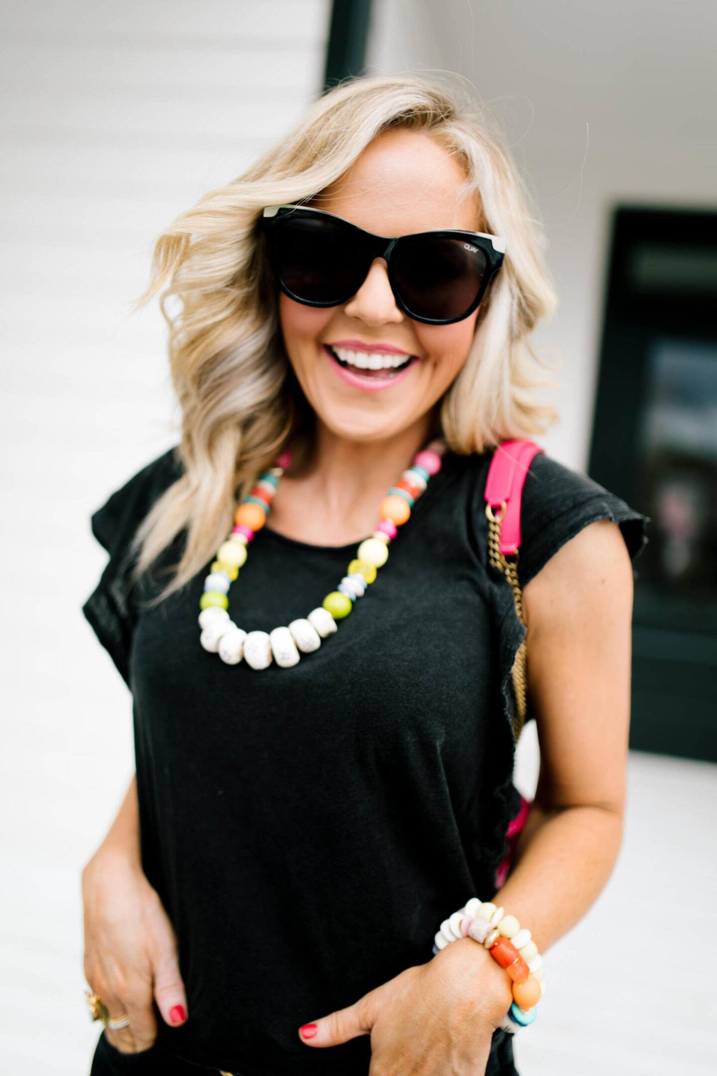 Anthropologie Sale by popular Nashville life and style blog, Hello Happiness: image of Natasha Stoneking wearing a black top and black shorts, and rainbow bead necklaces and bracelets.