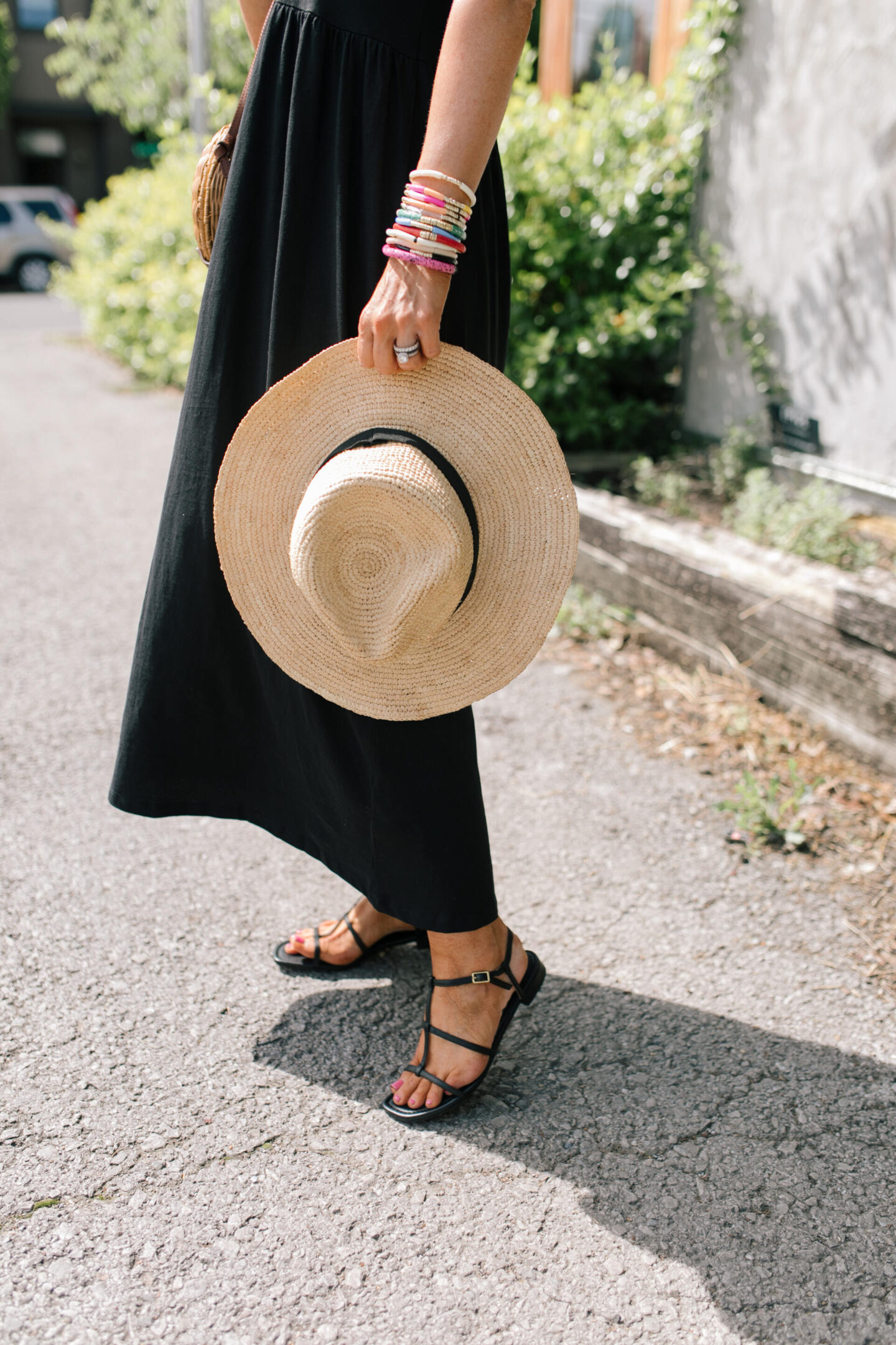 J Crew Clothing by popular Nashville fashion blog, Hello Happiness: image of a woman wearing a black J. Crew sleeveless maxi dress with black strap sandals and a straw sun hat.