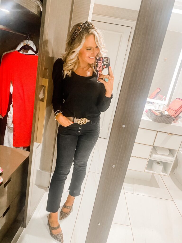 Hotel Crescent Court Dallas by popular Nashville travel blog, Hello Happiness: image of Natasha Stoneking standing in her room at the Hotel Crescent Court Dallas and wearing a Gucci belt, tweed headband, tiger print mules, black puff sleeve top and black crop jeans. 