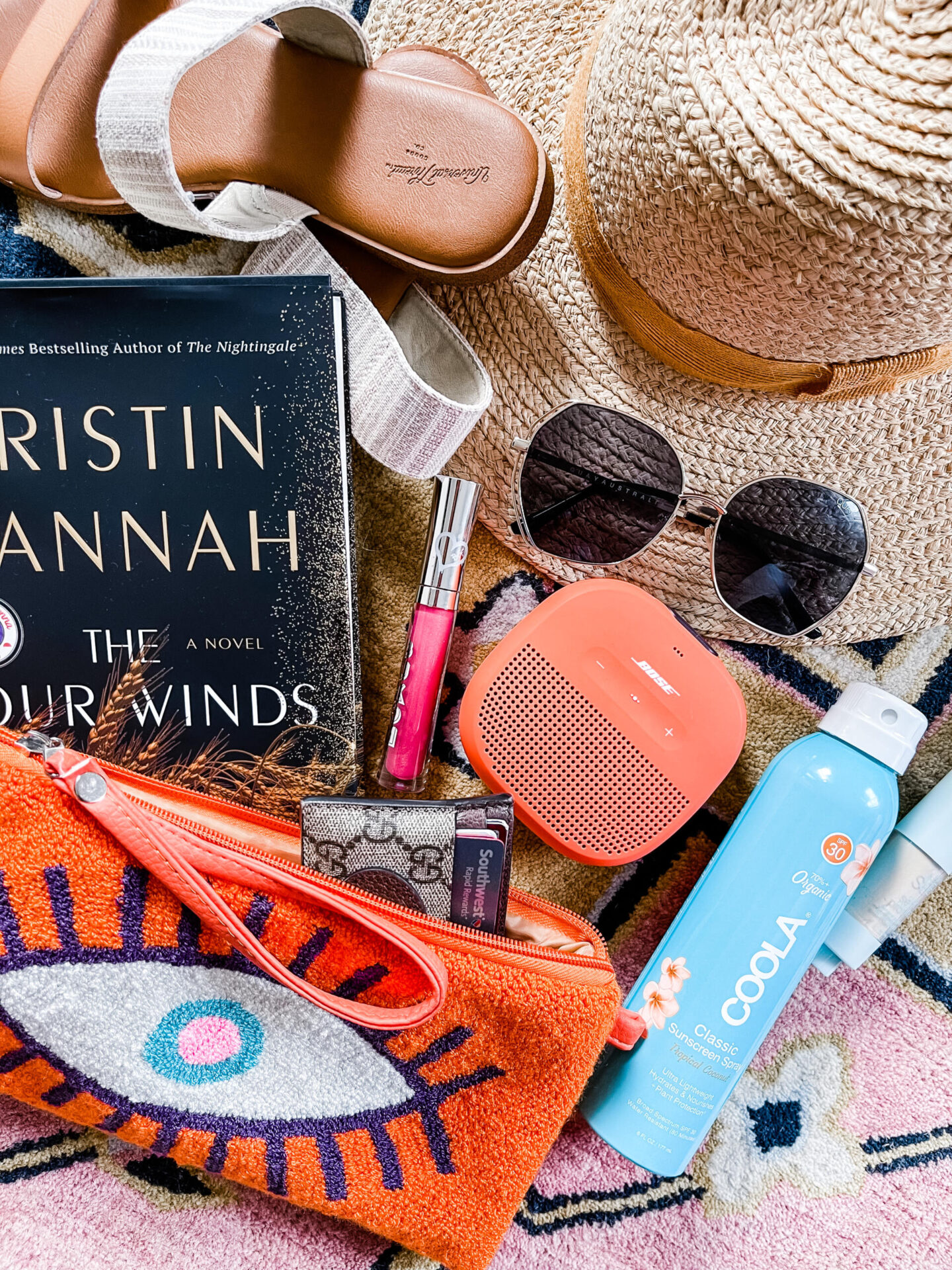 Spring Break Outfits by popular Nashville fashion blog, Hello Happiness: image of an evil eye clutch, two tone sandals, credit card wallet, big love sunglasses, soundlink speaker, buxom lipgloss, sunscreen and mineral spf. 