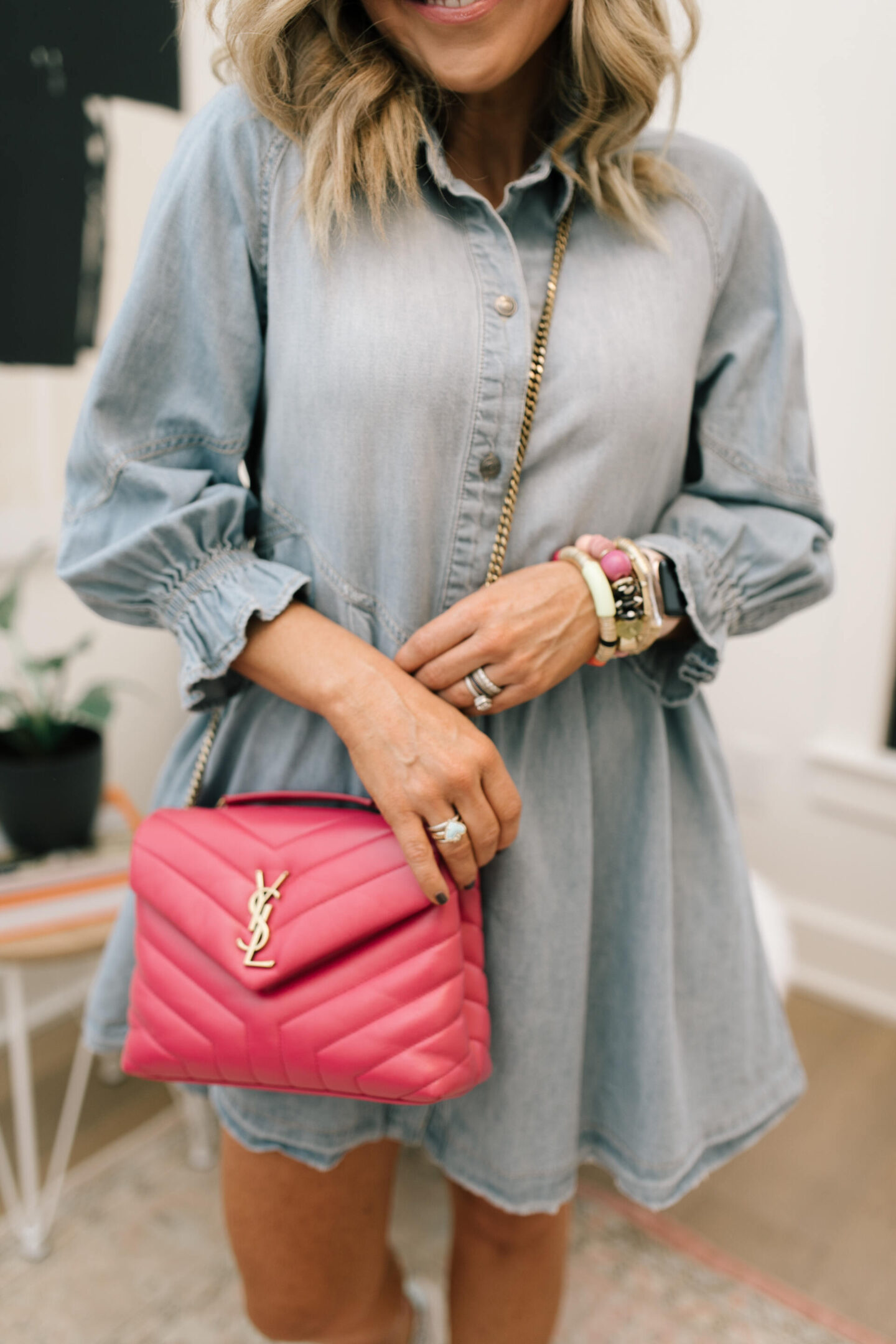 Denim Dresses by popular Nashville fashion blog, Hello Happiness: image of a woman wearing a Hannah mini denim dress, Zaga Glitter Sneakers, Ari Heart Ring, Natasha Beaded bracelet, Allie + Bess Zo Bracelets, and carrying a YSL pink small LouLou bag,