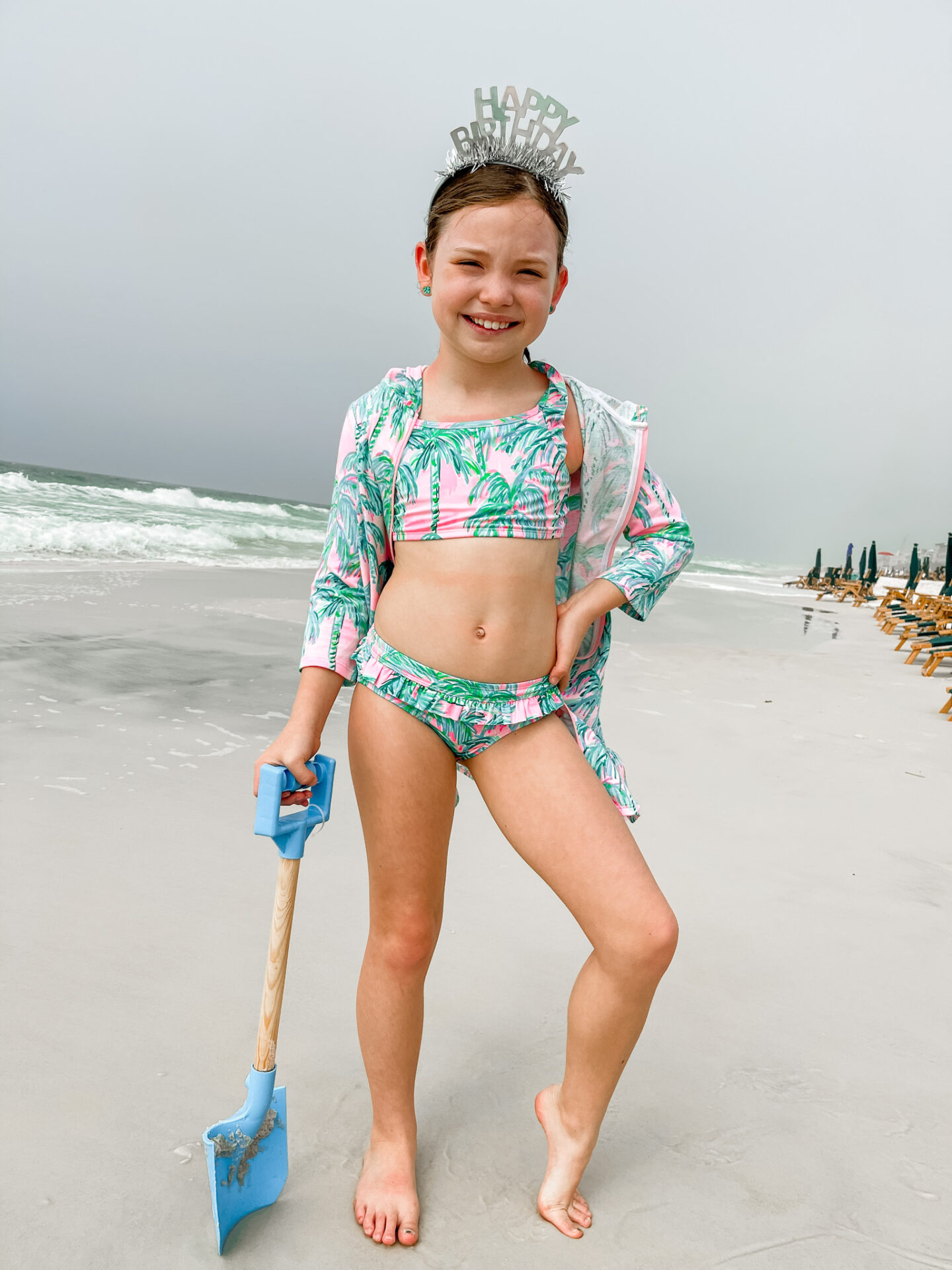 Spring Break Outfits by popular Nashville fashion blog, Hello Happiness: image of a young girl standing on a white sand beach and wearing a Janessa Bikini Set.
