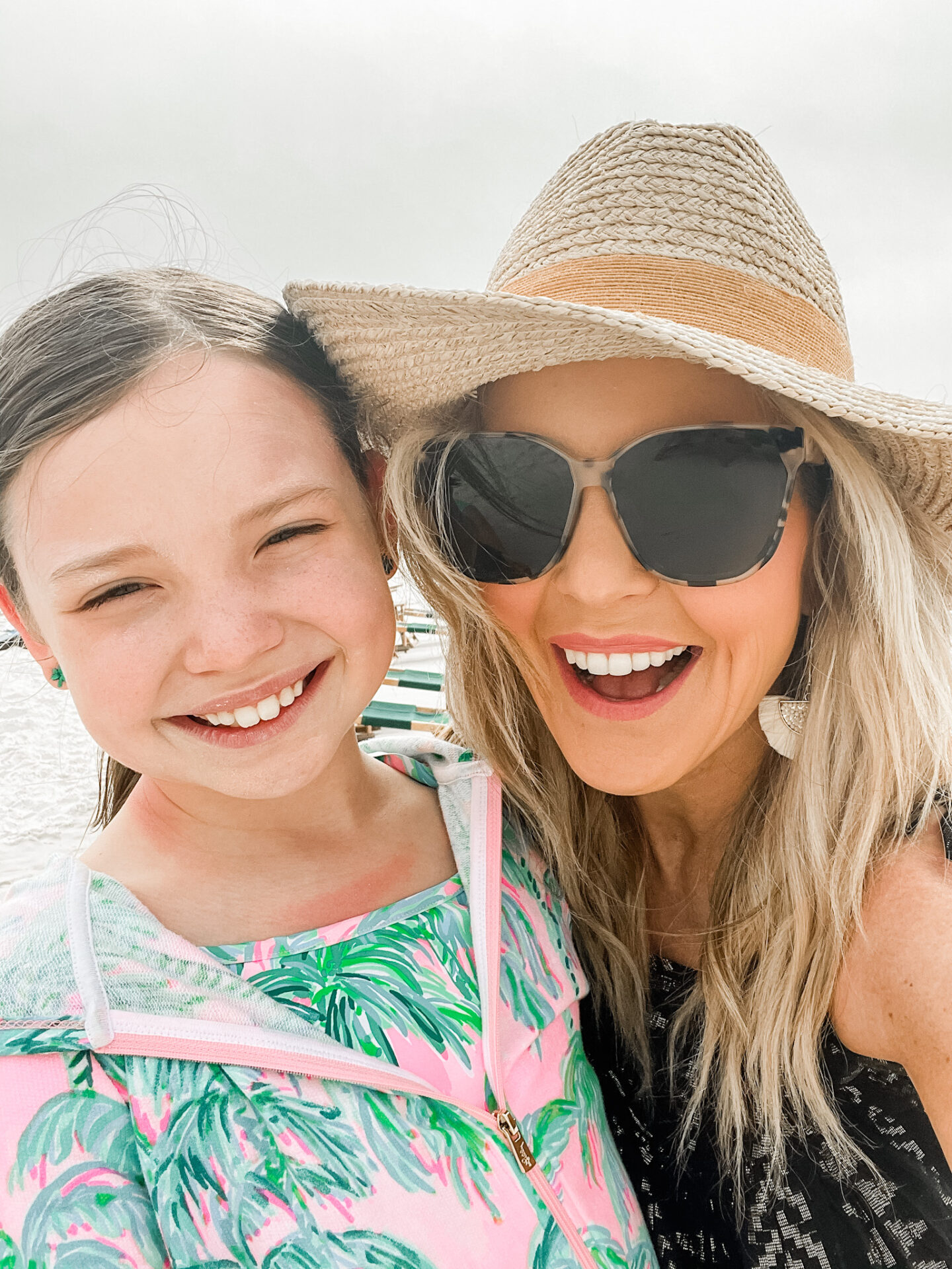 Spring Break Outfits by popular Nashville fashion blog, Hello Happiness: image of Natasha Stoneking and her daughter wearing a cooke cover up, Gia oversized sunglasses, and black and gold coverup dress.