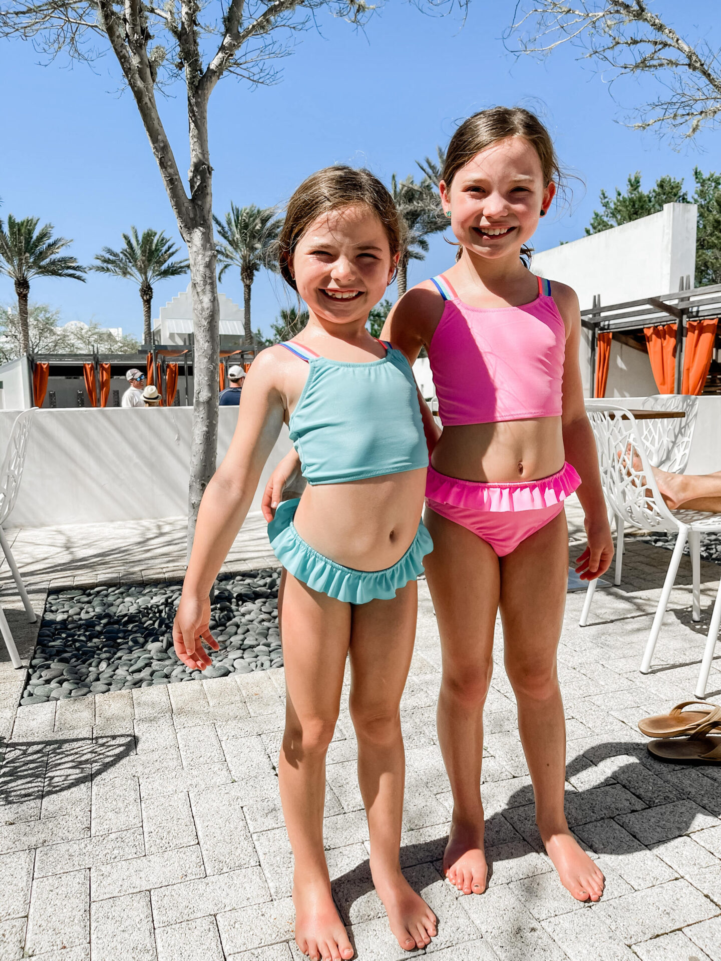Spring Break Outfits by popular Nashville fashion blog, Hello Happiness: image of two young girls standing together outside and wearing tankini swimsuits.