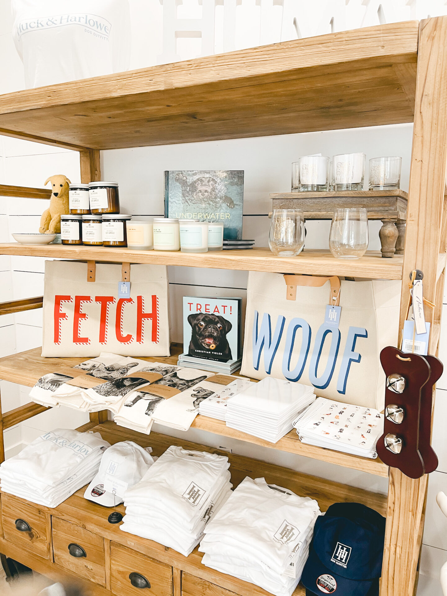 Dog Shops by popular Nashville lifestyle blog, Hello Happiness: image of Huck and Harlowe t-shirts, hats and hand towels on display next to some stemless wineglasses, mason jar candles, and fetch and woof totes. 
