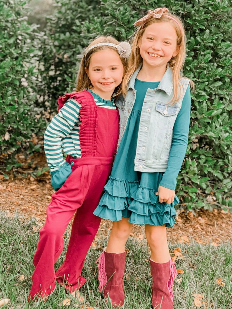 Caroline and Carson's Daily Style... Fall Fashion 2019 Edition by popular Nashville fashion blog, Hello Happiness: image of two little girls standing next to each other outside and wearing a Matilda Jane Clothing Science Central Romper and Matilda Jane Clothing Veggie Stand Dress.