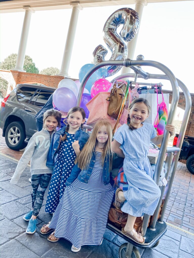 Gaylord Soundwaves by popular Nashville lifestyle blog, Hello Happiness: image of 4 girls standing next to a luggage cart containing a balloon bouquet and luggage. 