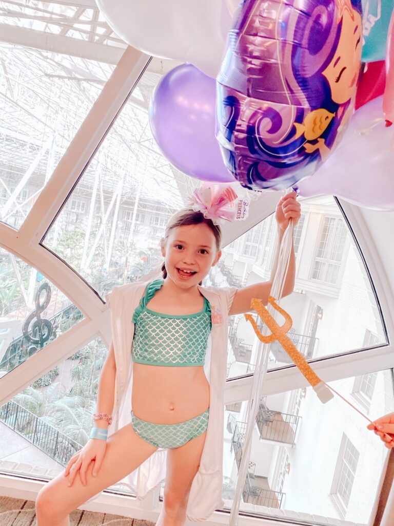 Gaylord Soundwaves by popular Nashville lifestyle blog, Hello Happiness: image of a young girl wearing a Elegant Goods mermaid squad coverup and Target More Than Magic Mermaid Ruffle Sleeve Bikini Swimsuit Set.