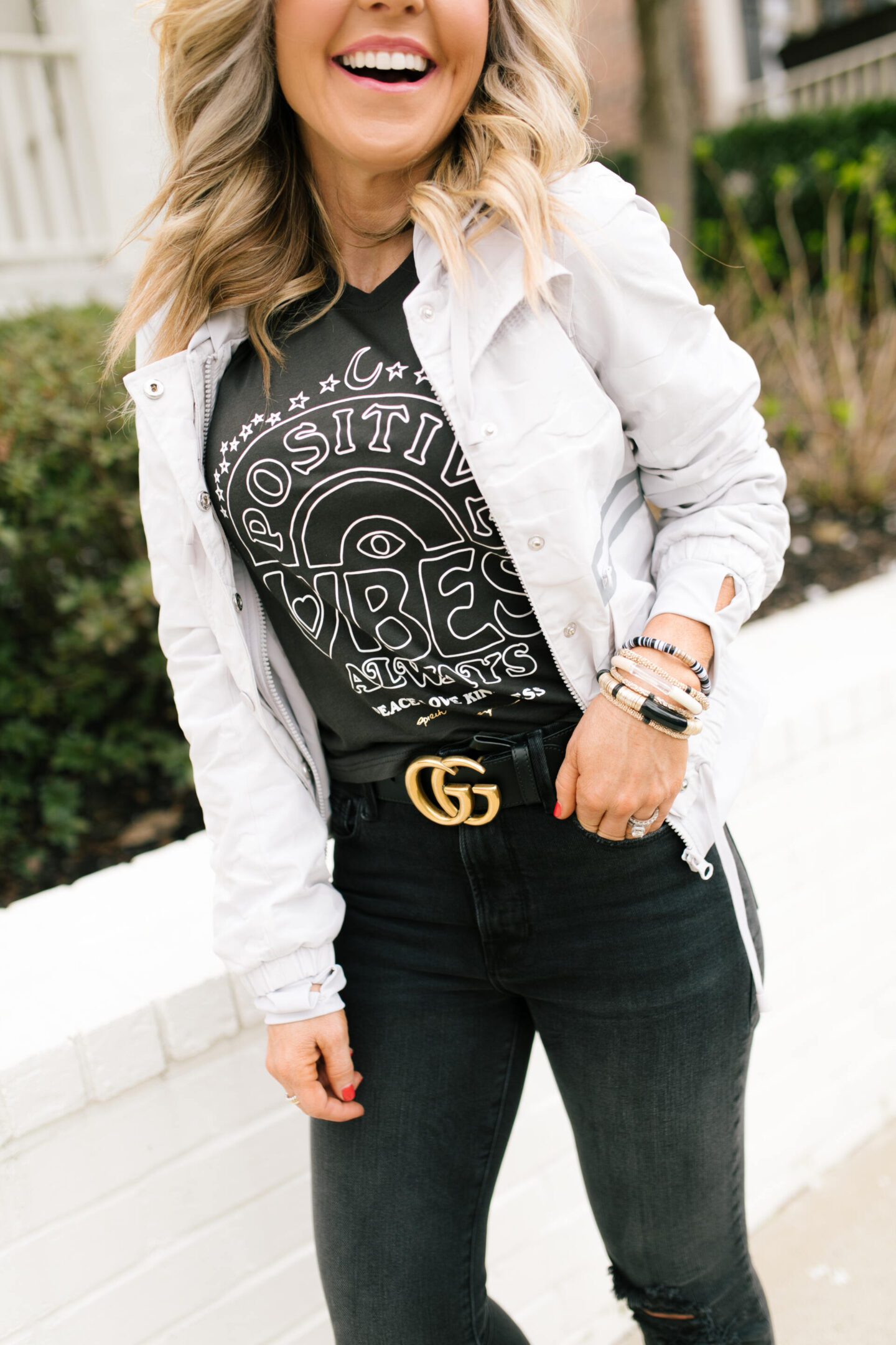 Memorial Day Sales by popular Nashville life and style blog, Hello Happiness: image of Natasha Stoneking wearing a Evereve positive vibes only tank with a Gucci belt, black jeans, and white jacket.