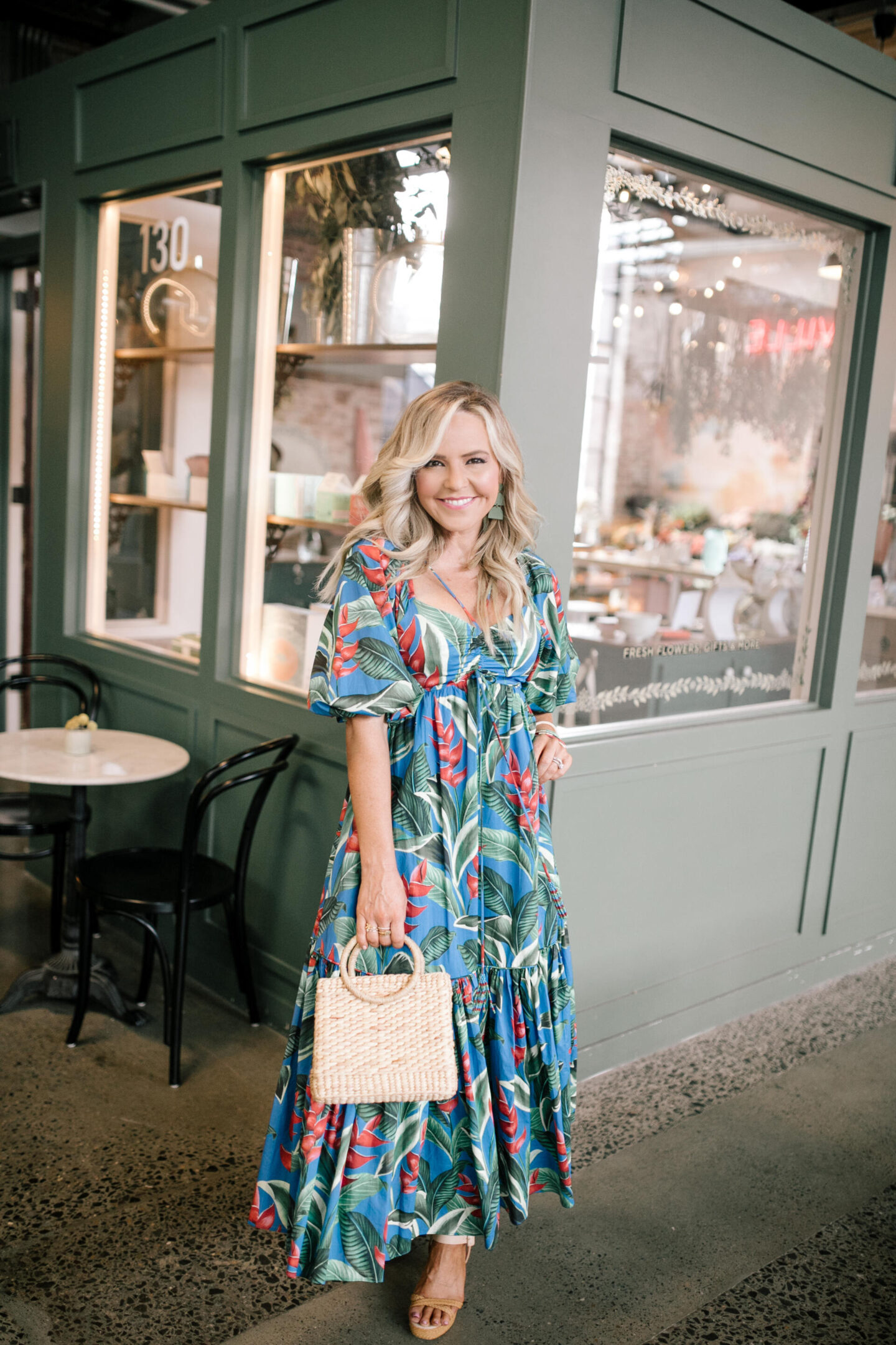 Birthday Wishlist by popular Nashville life and style blog, Hello Happiness: image of a woman wearing a Dream Garden midi dress and holding a woven hand bag.