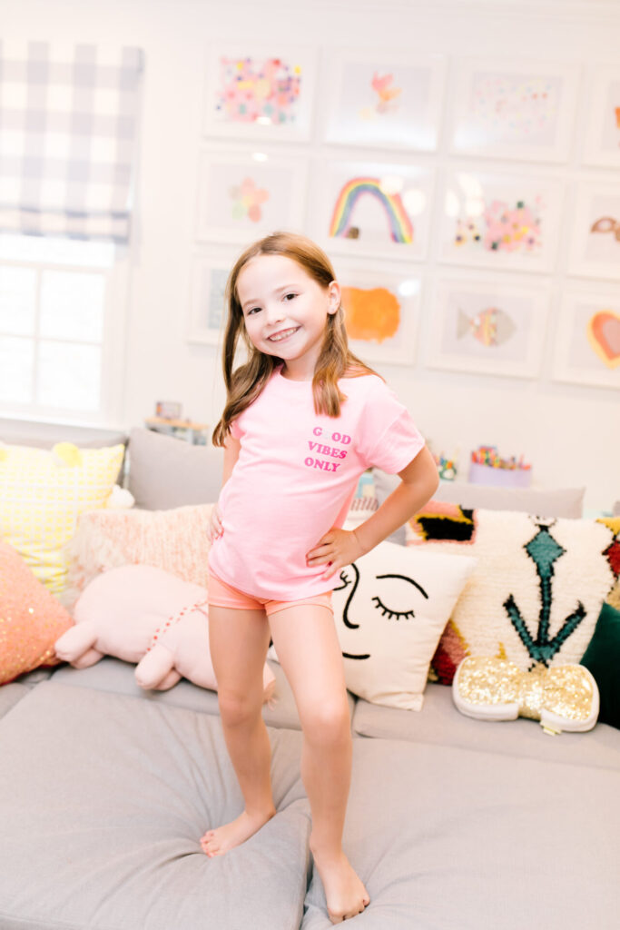 Tween Fashion by popular Nashville fashion blog, Hello Happiness: image of a girl standing on a grey couch and wearing Target gym shorts and a Target Good Vibes Only t-shirt.