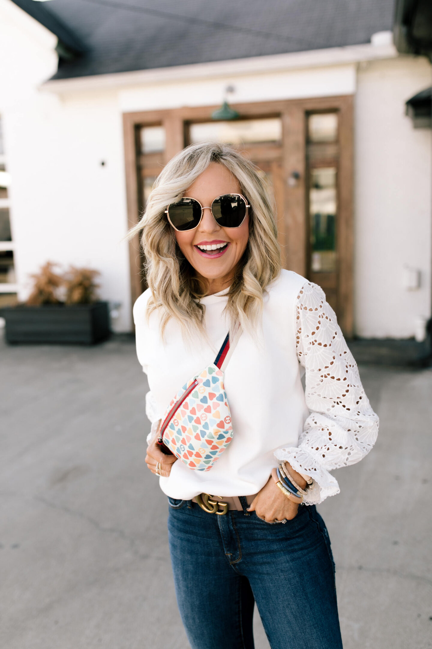 Belt Bag by popular Nashville fashion blog, Hello Happiness: image of Natasha Stoneking wearing a white long sleeve eyelet shirt jeans, Gucci double G belt and heart belt bag.