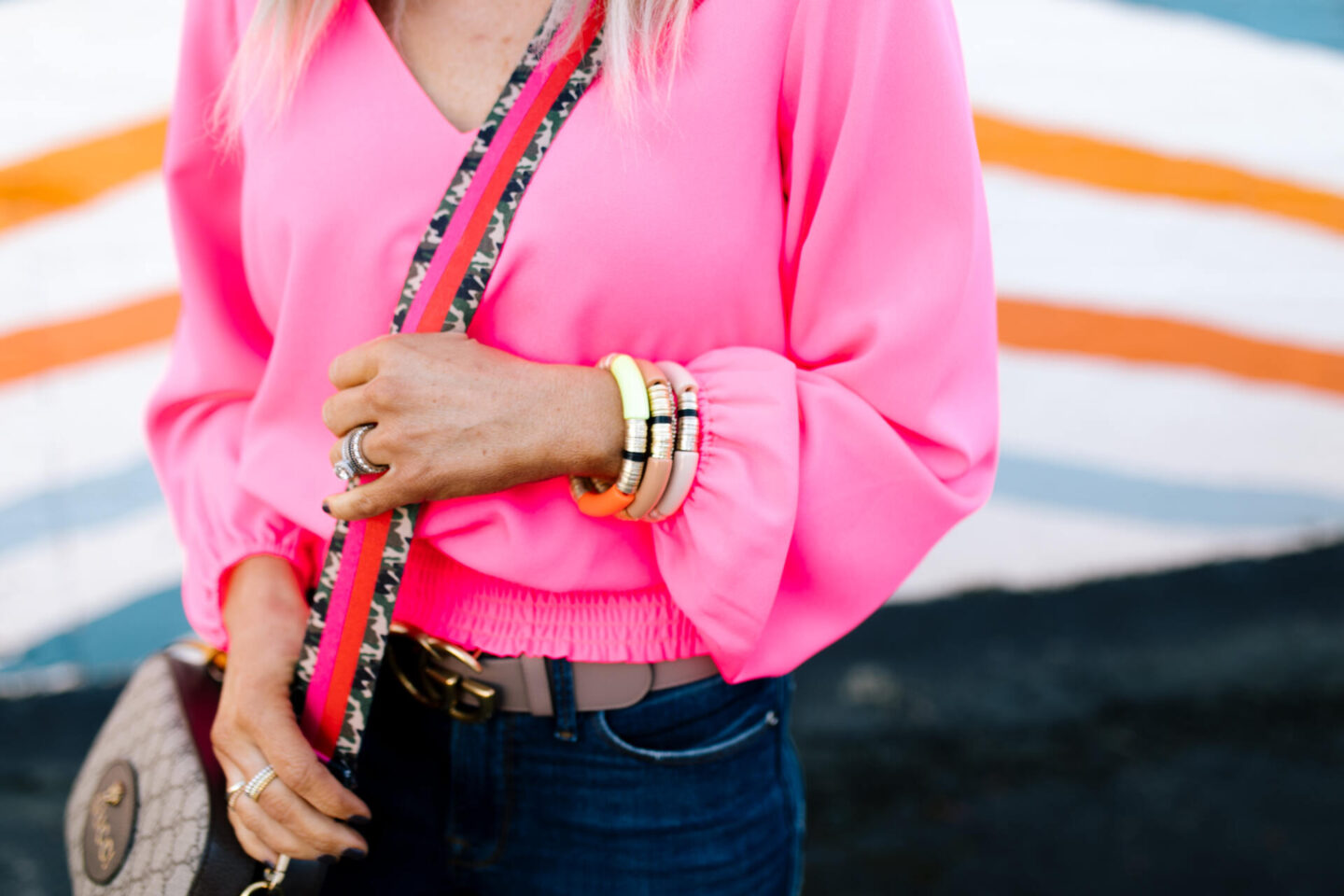Collaborations and Partnerships by popular Nashville lifestyle blog, Hello Happiness: image of woman wearing a pink bell sleeve blouse, Gucci belt, and jeans. 