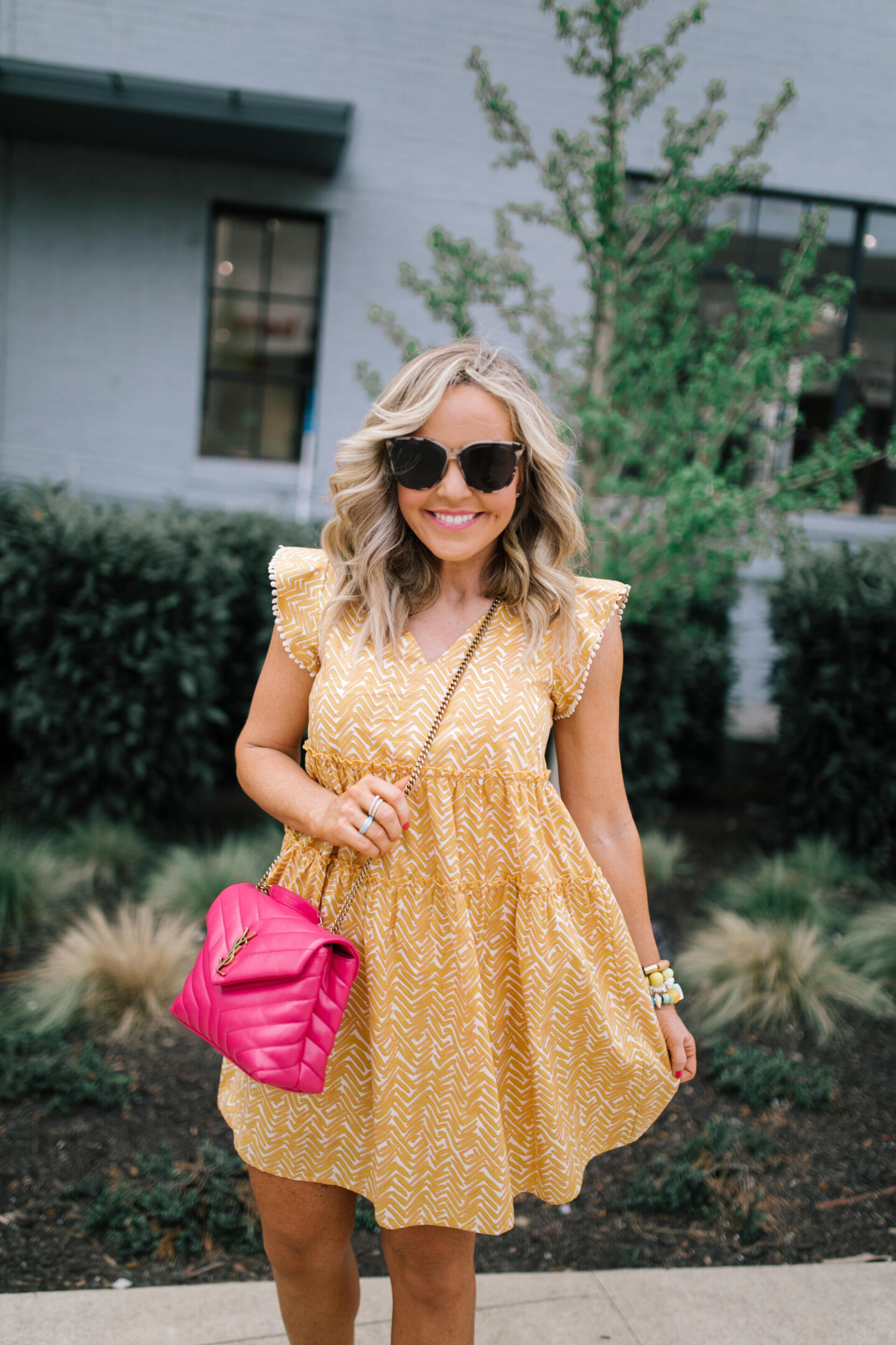 Summer Dresses by popular Nashville of Natasha Stoneking wearing a abstract flutter sleeve dress and carrying a YSL pink bag. 