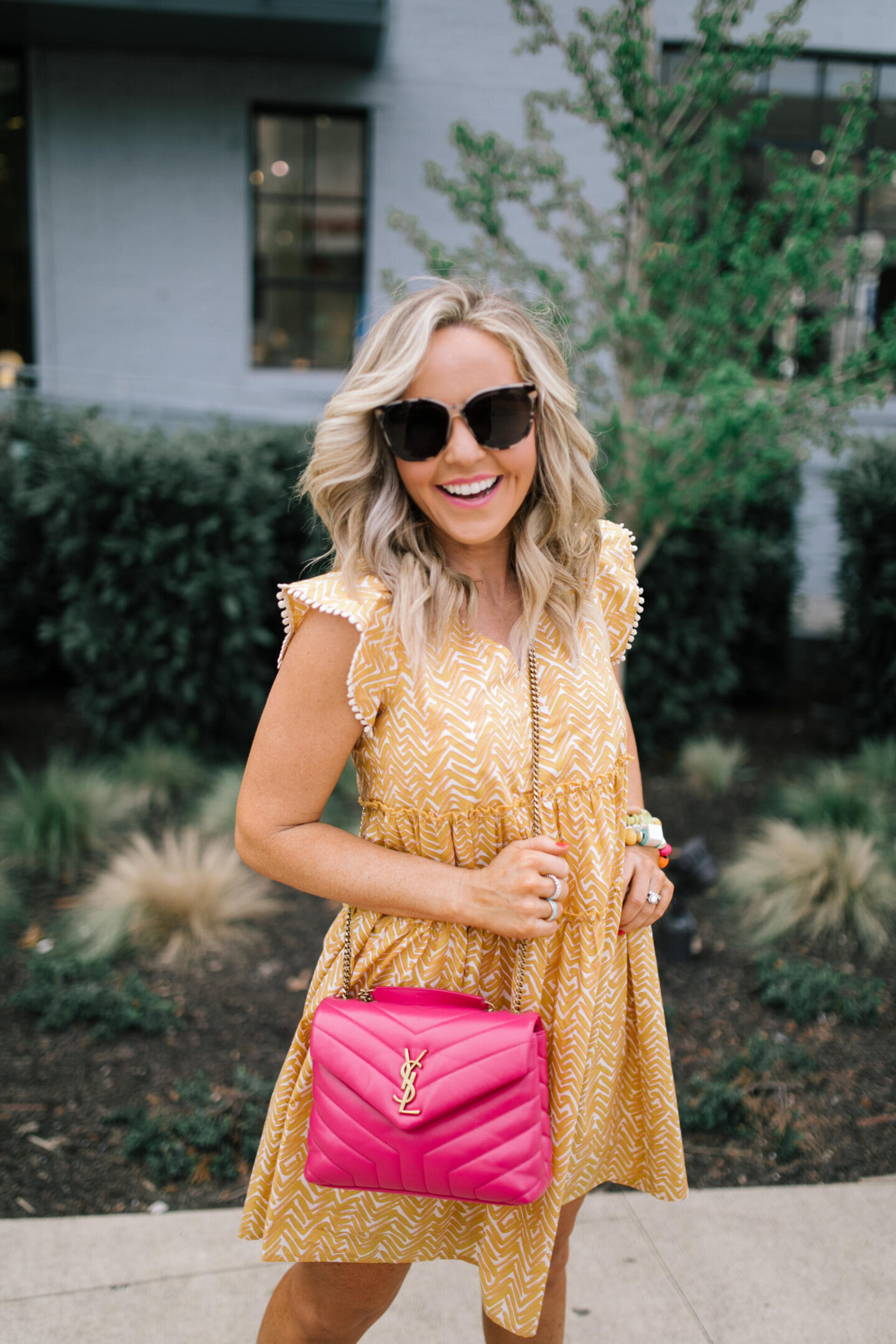 Summer Dresses by popular Nashville of Natasha Stoneking wearing a abstract flutter sleeve dress and carrying a YSL pink bag.