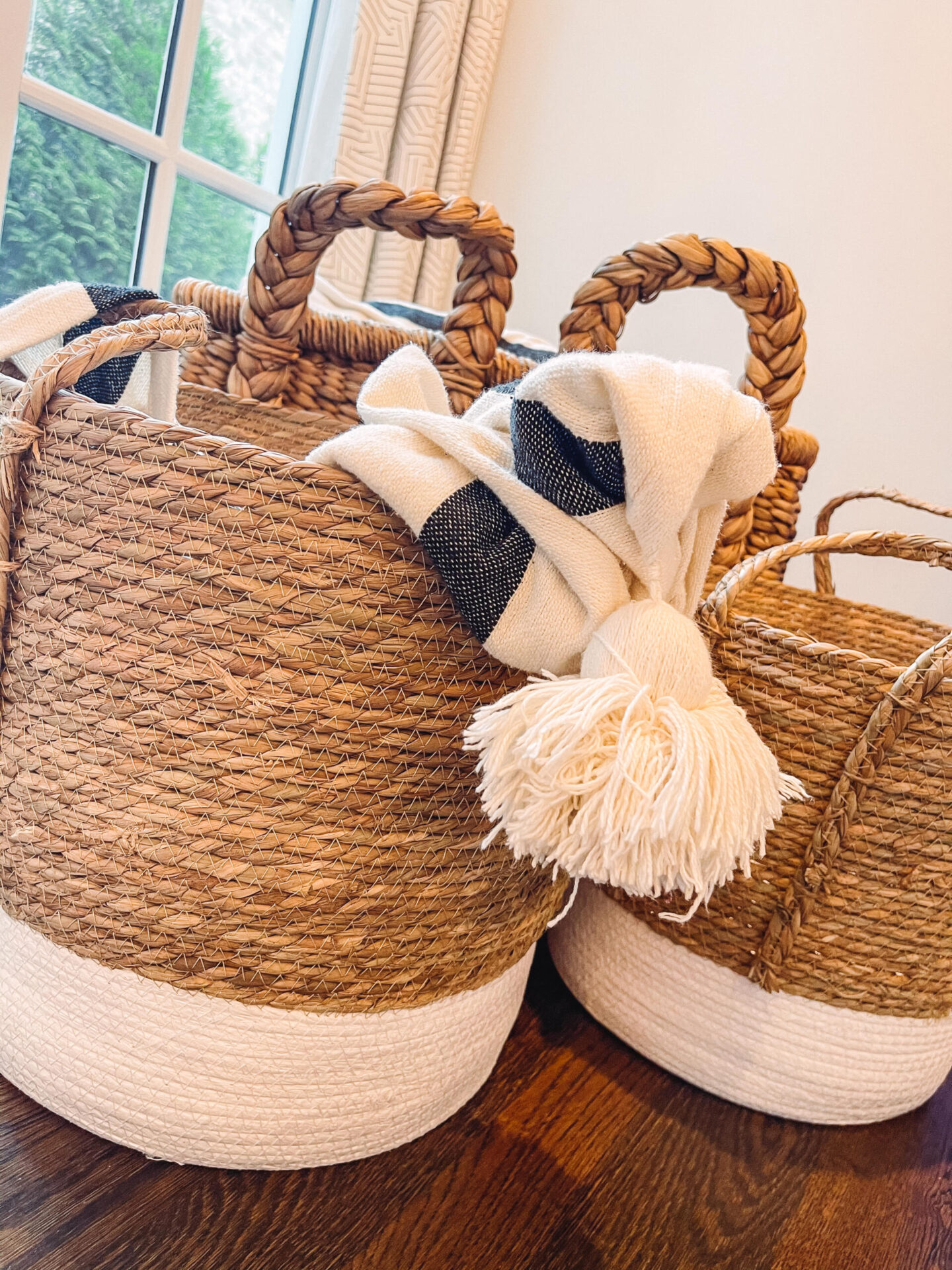 Walmart Summer by popular Nashville life and style blog, Hello Happiness: image of brown and white woven baskets with a black and cream stripe tassel blanket. 