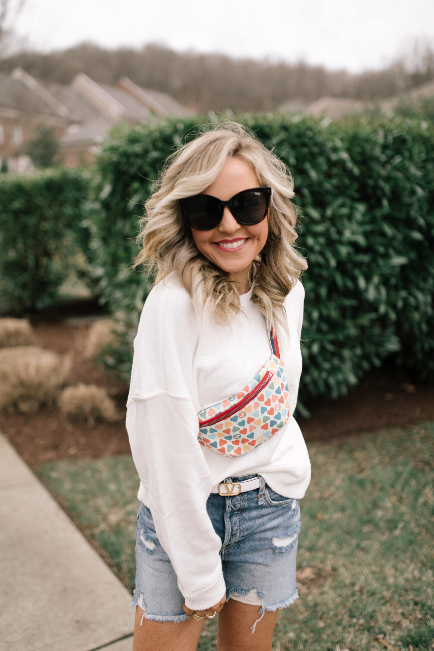Belt Bag by popular Nashville fashion blog, Hello Happiness: image of Natasha Stoneking wearing a Ocean Drive White Terry Sweatshirt, cuttoff shorts, and heart belt bag.