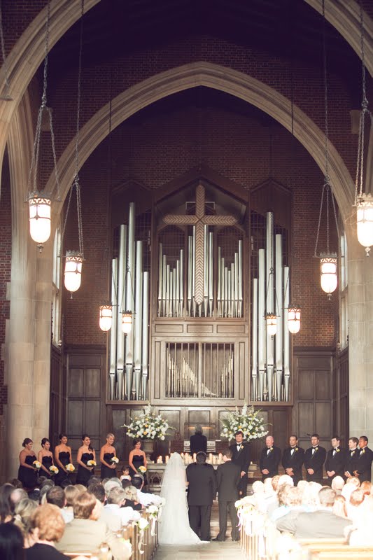 10 Year Wedding Anniversary by popular Nashville lifestyle blog, Hello Happiness: image of a bride and groom getting married in a cathedral filled with people and a wedding party wearing all black and standing up front.