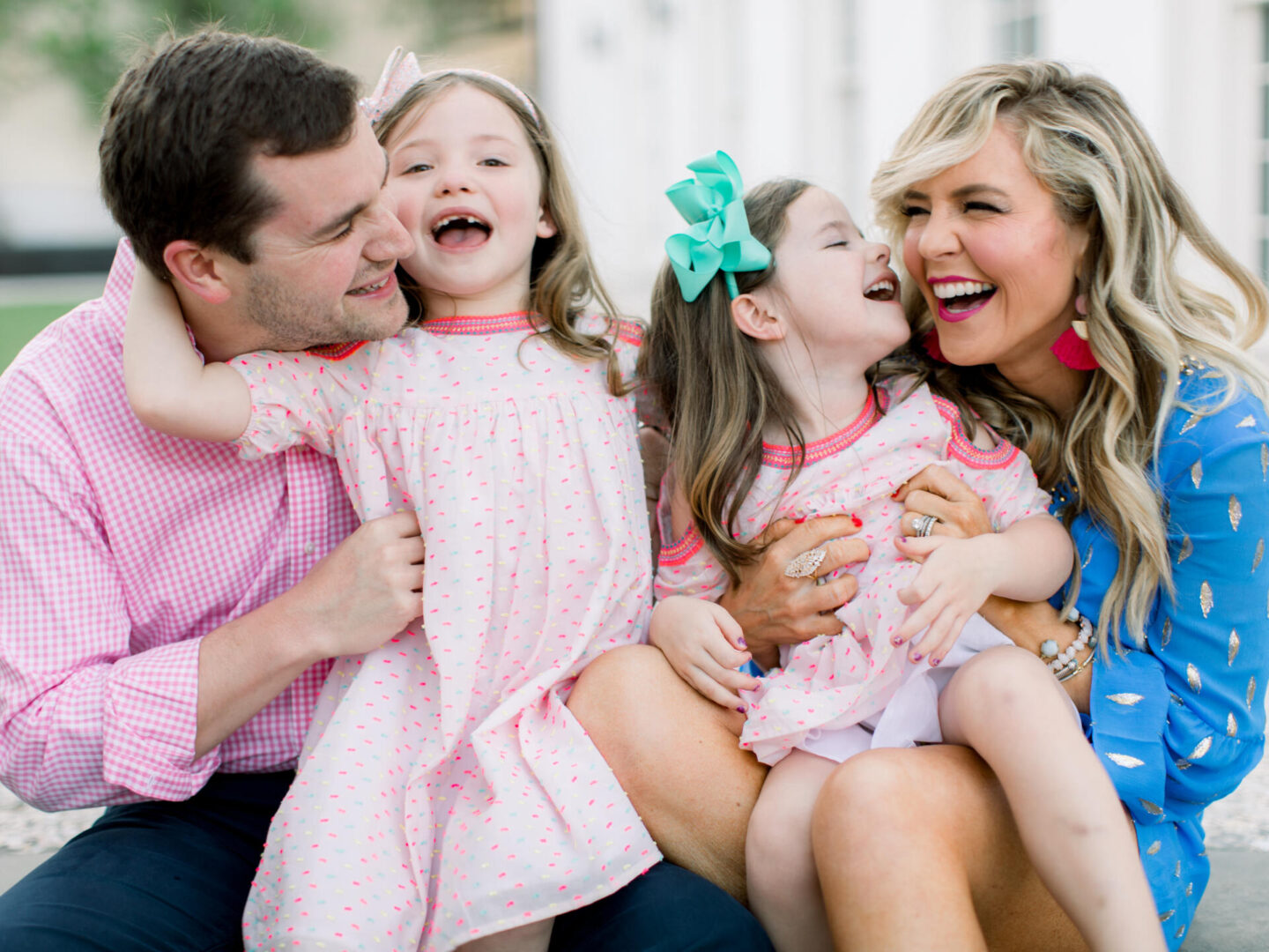 10 Year Wedding Anniversary by popular Nashville lifestyle blog, Hello Happiness: image of a mom and dad and their two young daughters sitting together.