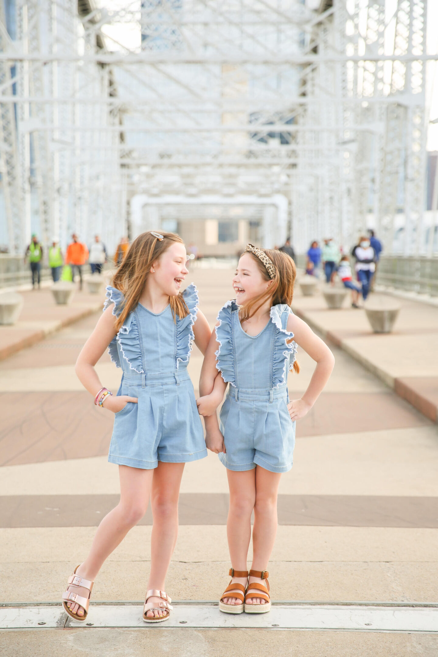 Summer Bucket List by popular Nashville lifestyle blog, Hello Happiness: image of two young girls holding hands and wearing matching chambray rompers and brown sandals.