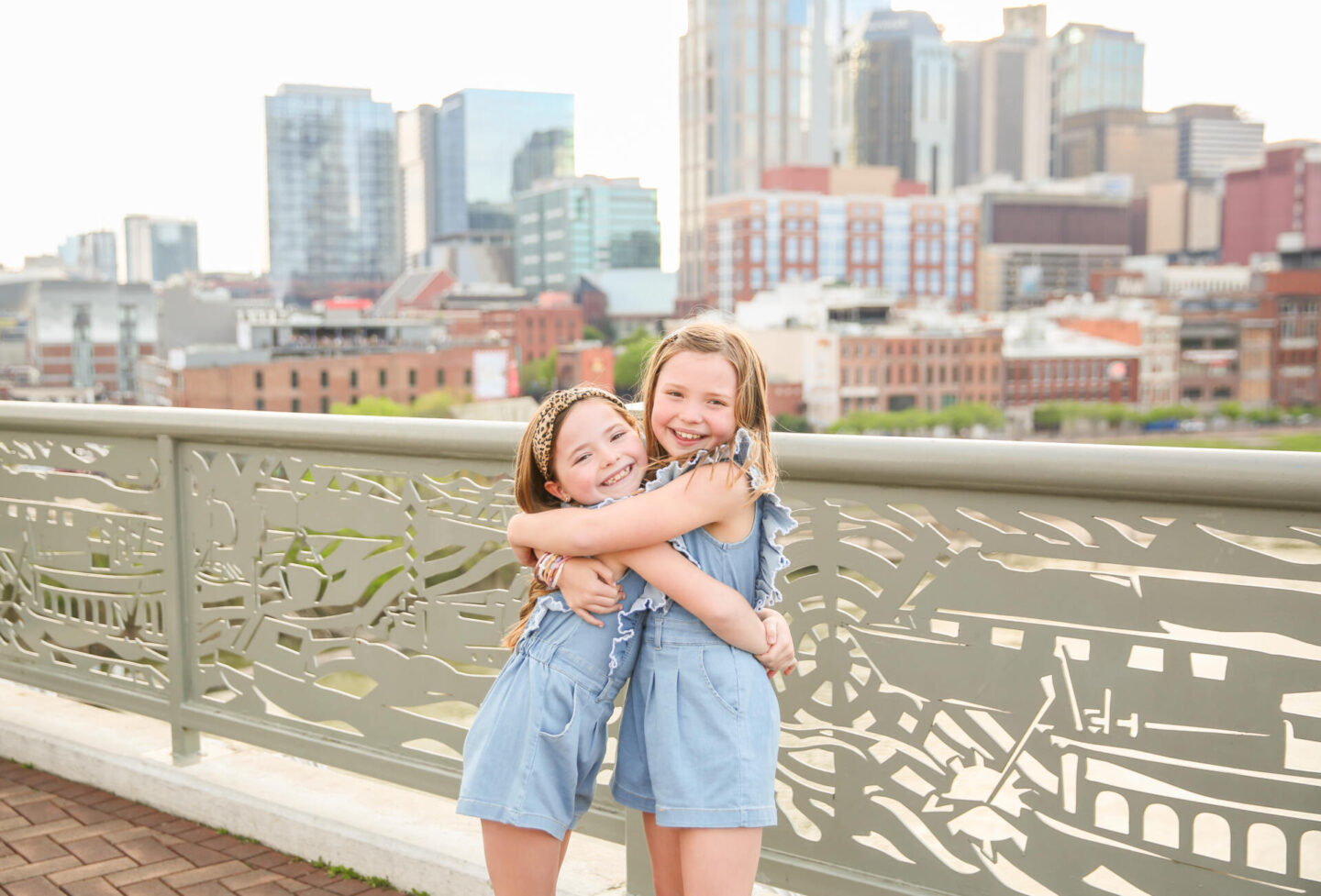 Summer Bucket List by popular Nashville lifestyle blog, Hello Happiness: image of two young girls holding hands and wearing matching chambray rompers and brown sandals. 