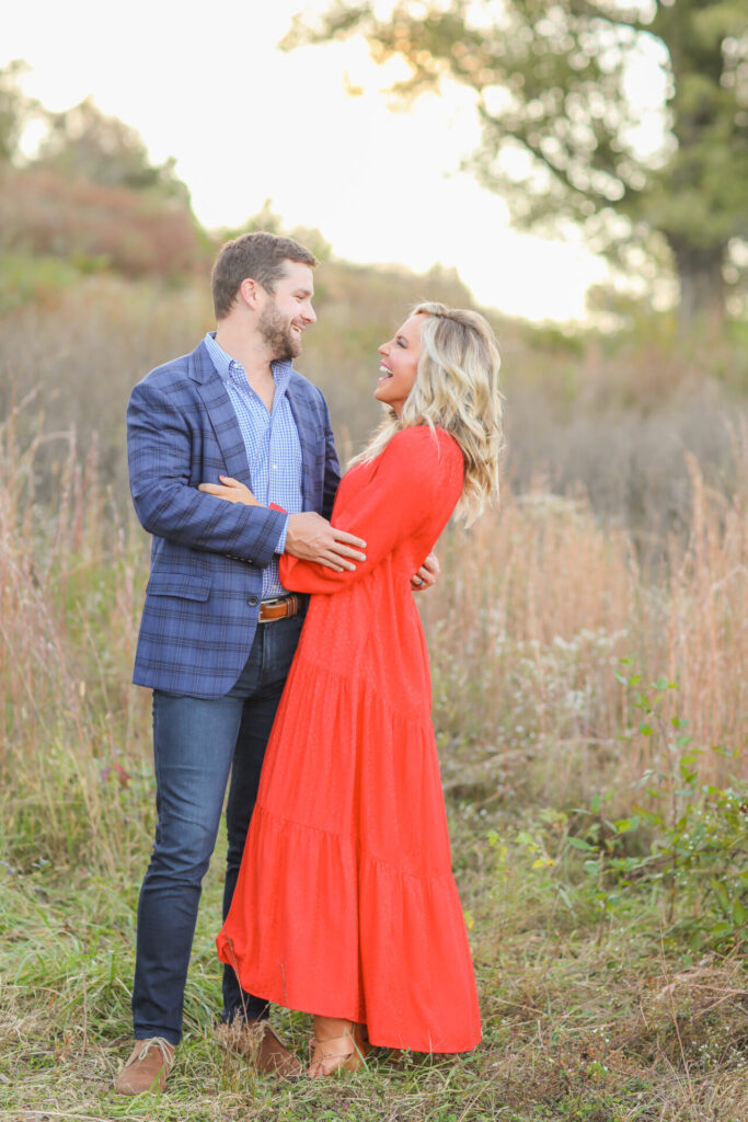 Relationship Advice by popular Nashville lifestyle blog, Hello Happiness: image of a husband and wife standing together in a field and wearing a tiered red maxi dress and blue plaid blazer. 